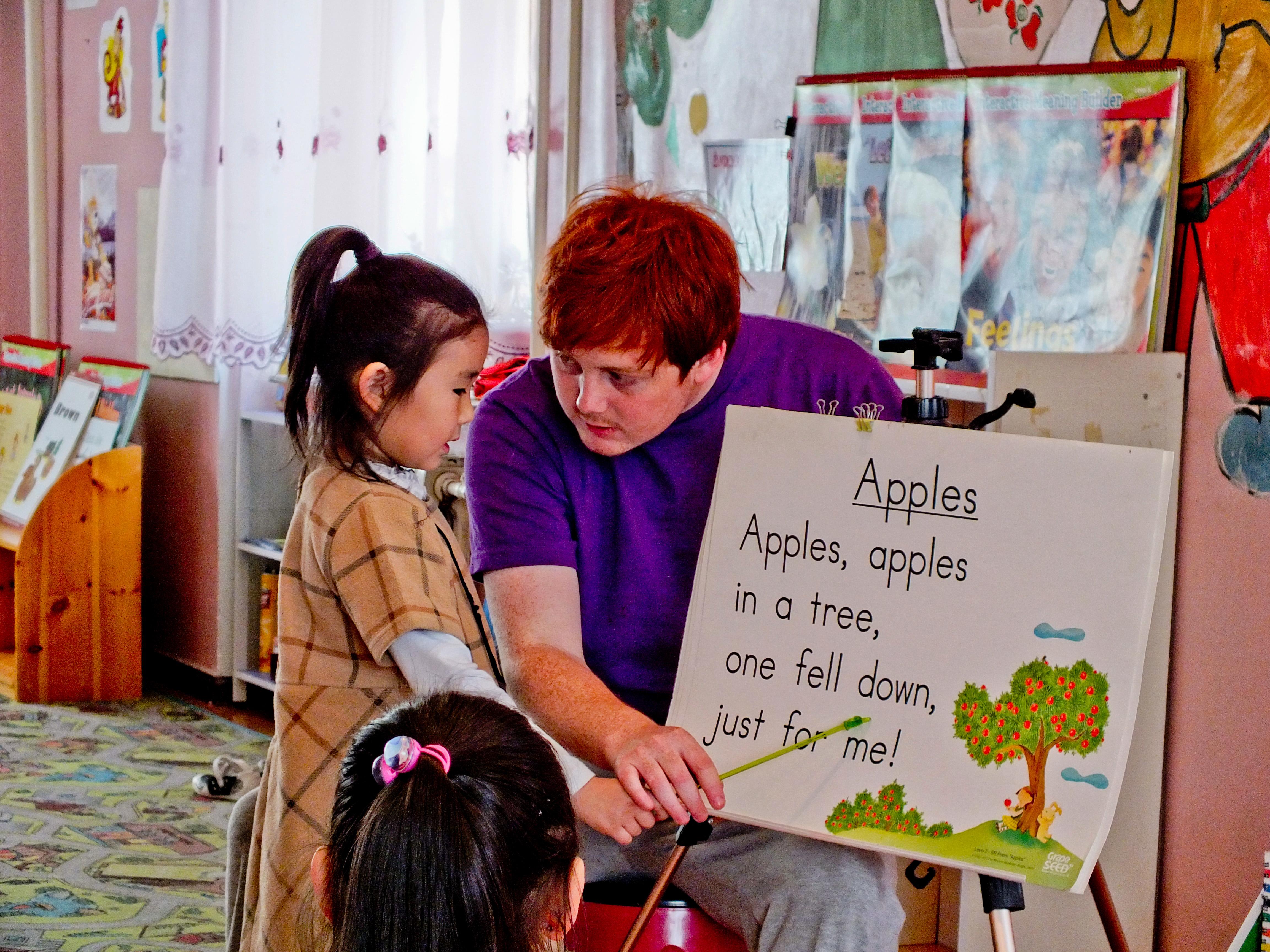 A Projects Abroad volunteer teaching English in Mongolia helps recite an English verse with his student A young girl learns how to say an English phrase at our volunteer teaching placements in Mongolia